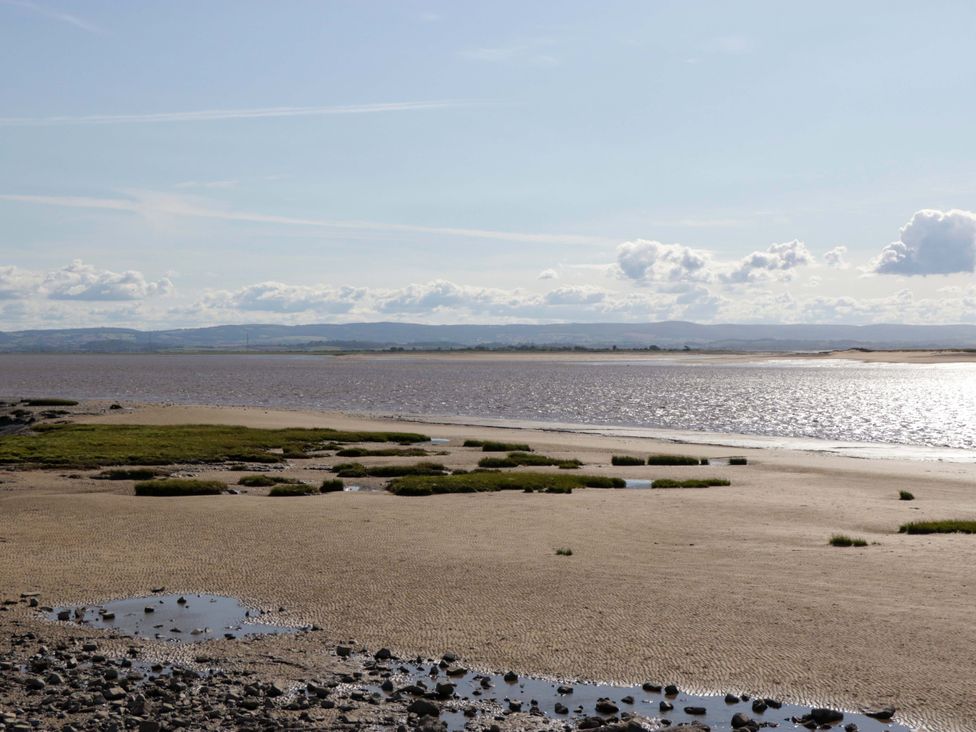 A view of a riverbank with sand and grass at Flat 24 in Brean