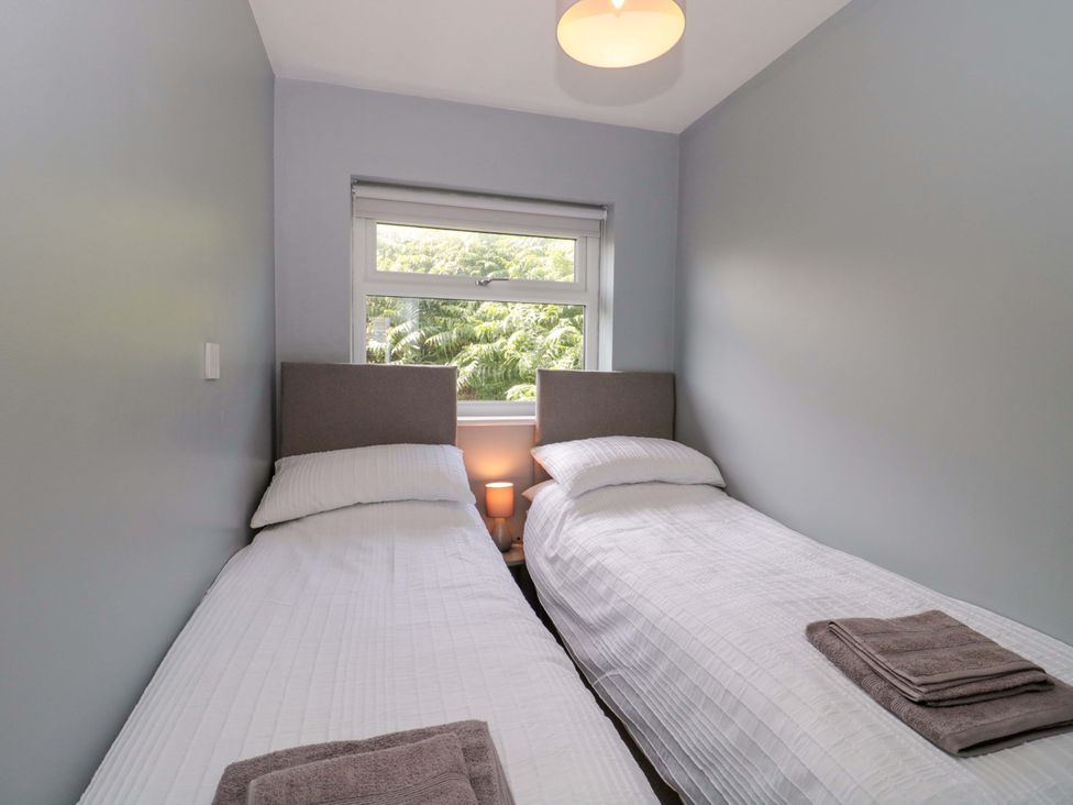 A bedroom with two single beds and a window at Flat 24 in Brean