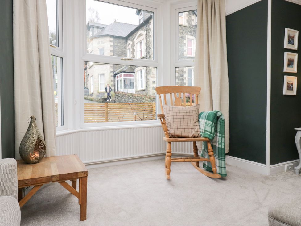 A living room with a rocking chair and a wooden table at The Wonky Nest Bowness-On-Windermere