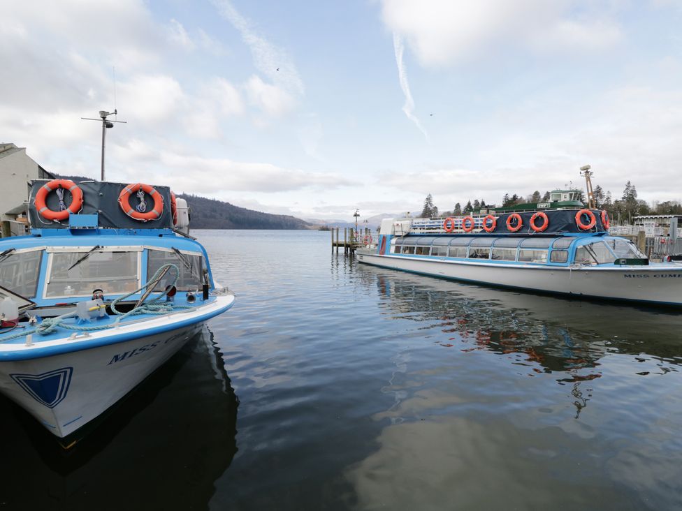 Two boats docked on water with life jackets in view at The Wonky Nest in Bowness-On-Windermere