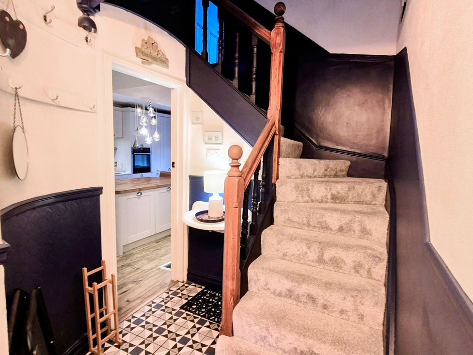 A hallway with a staircase leading upstairs at The Wonky Nest in Bowness-On-Windermere