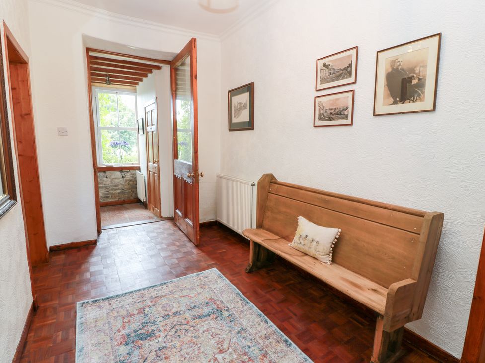 A hallway with a bench and pictures on the wall at Balsaggart Farm