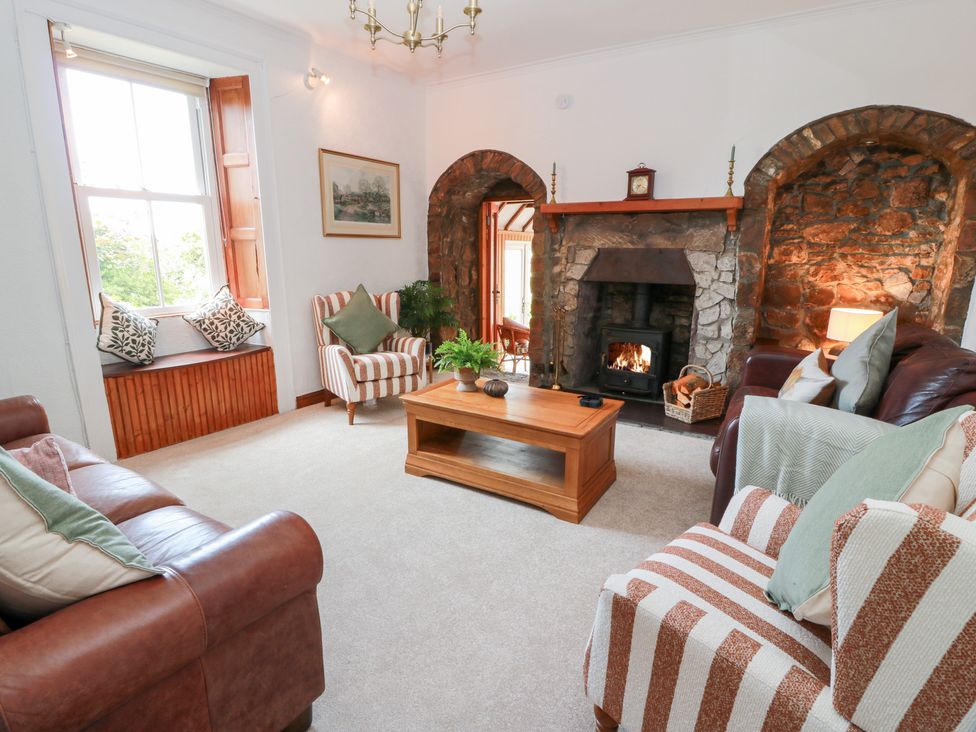 A living room with a fireplace and seating at Balsaggart Farm 