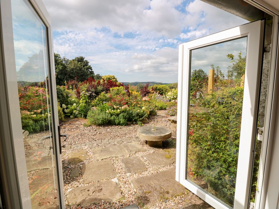 A garden view from an open door at Balsaggart Farm
