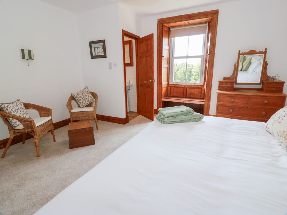 A bedroom with a bed, dresser, and seating area at Balsaggart Farm