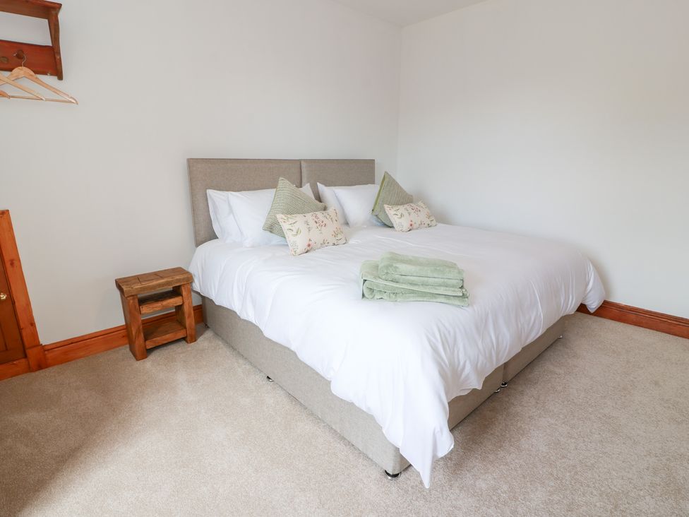 A bedroom with a bed and nightstand at Balsaggart Farm 