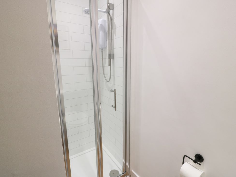 A shower with glass door in a bathroom at Balsaggart Farm