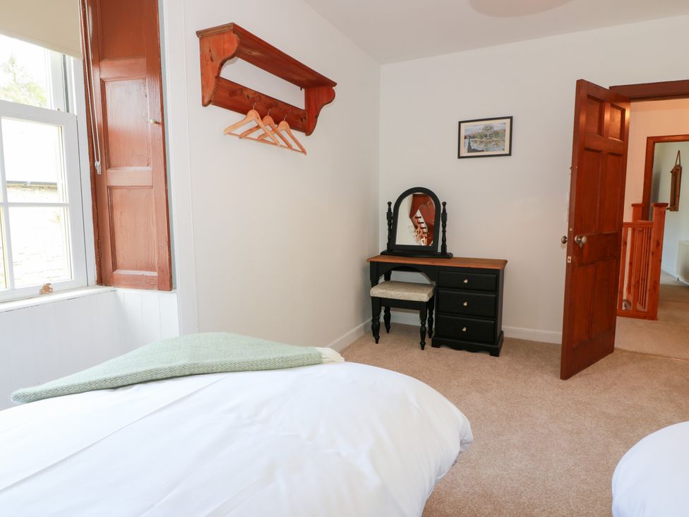 A bedroom with a bed and a mirror at Balsaggart Farm