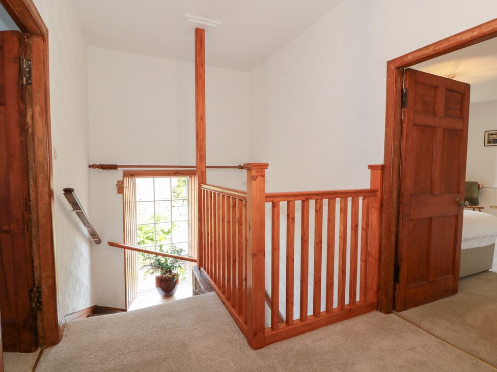 A hallway with a staircase and wooden features at Balsaggart Farm