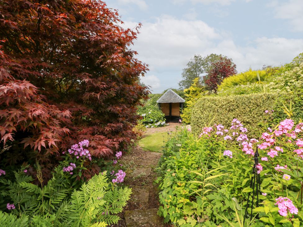 A garden with a pathway and flowers at Balsaggart Farm