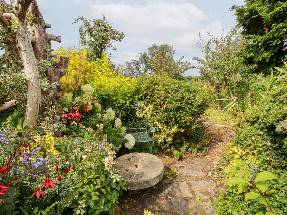 A garden with a stone path and a bench at Balsaggart Farm