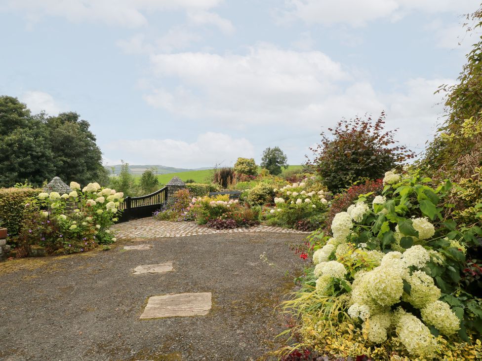A garden with flowers and a pathway at Balsaggart Farm