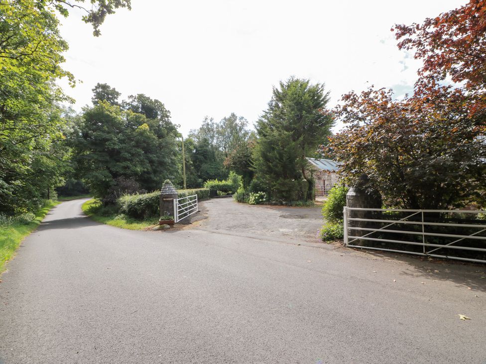A road intersection with a gate and trees at Balsaggart Farm