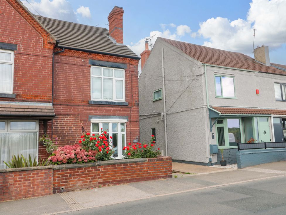 A view of two houses with flowers in front at Alfreton Cottage in Newton near Alfreton