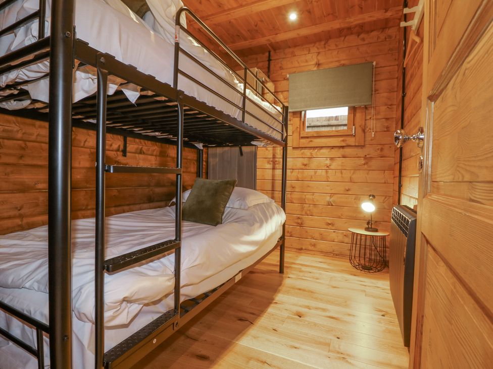 A bedroom with a bunk bed and lamp at Bee Hive South Luffenham near Edith Weston