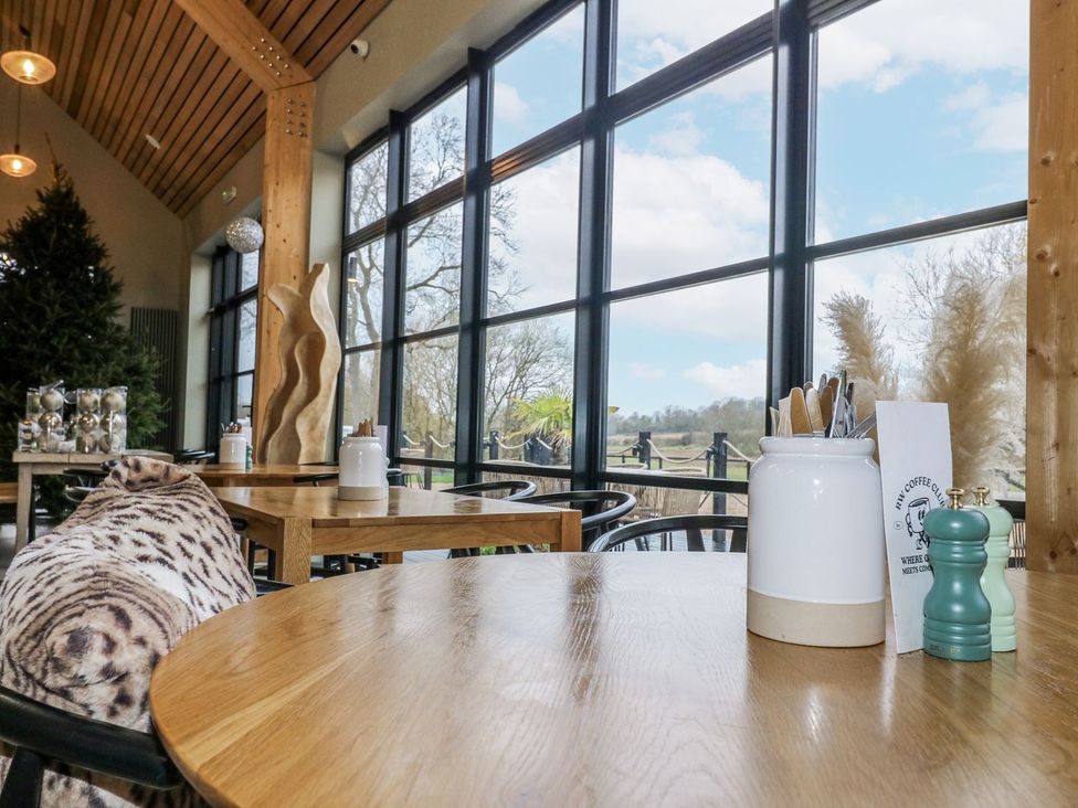A restaurant with large windows and tables at Badger's Burrow in Edith Weston