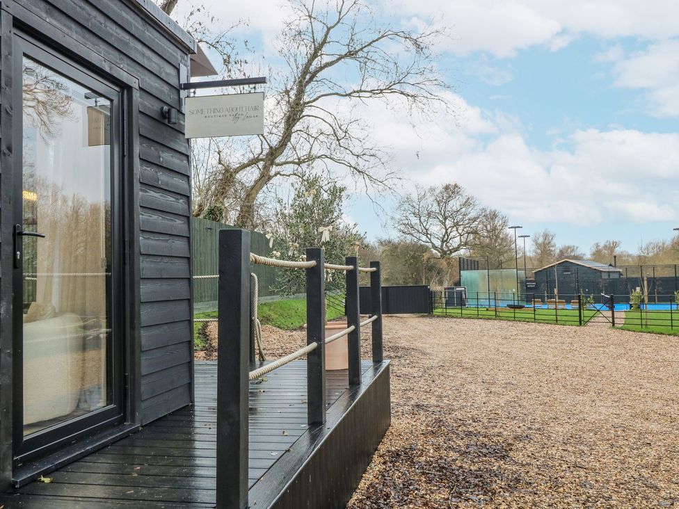 An outdoor area with a deck and gravel near a building at Badger's Burrow in Edith Weston