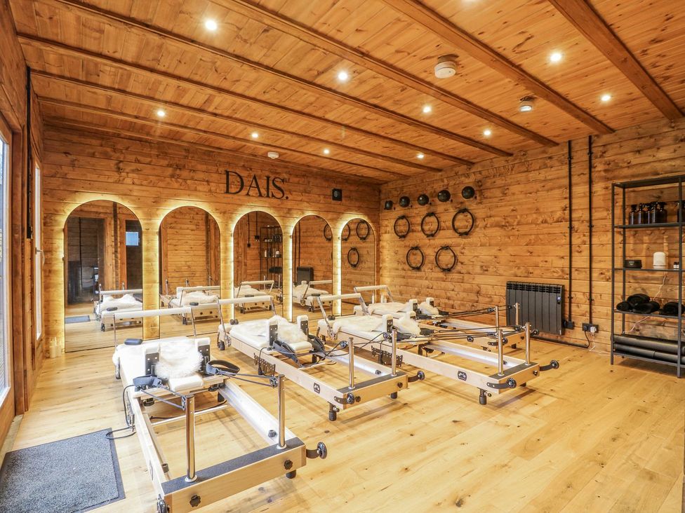 An exercise studio with pilates reformers and wooden decor at Badger's Burrow in Edith Weston