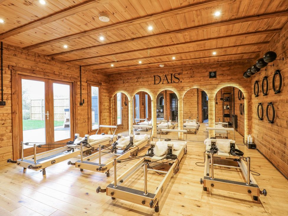 A studio with pilates reformers and wooden walls at Badger's Burrow in Edith Weston