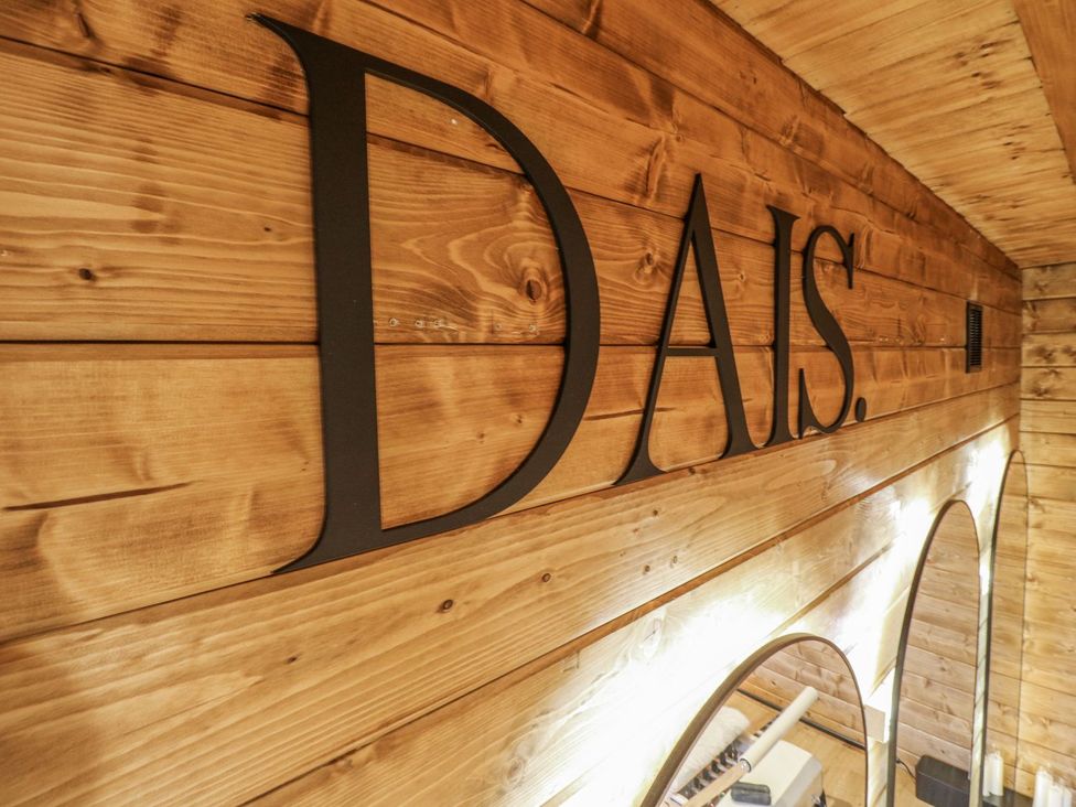 A wooden wall with the word DAIS and mirrors at Badger's Burrow in Edith Weston