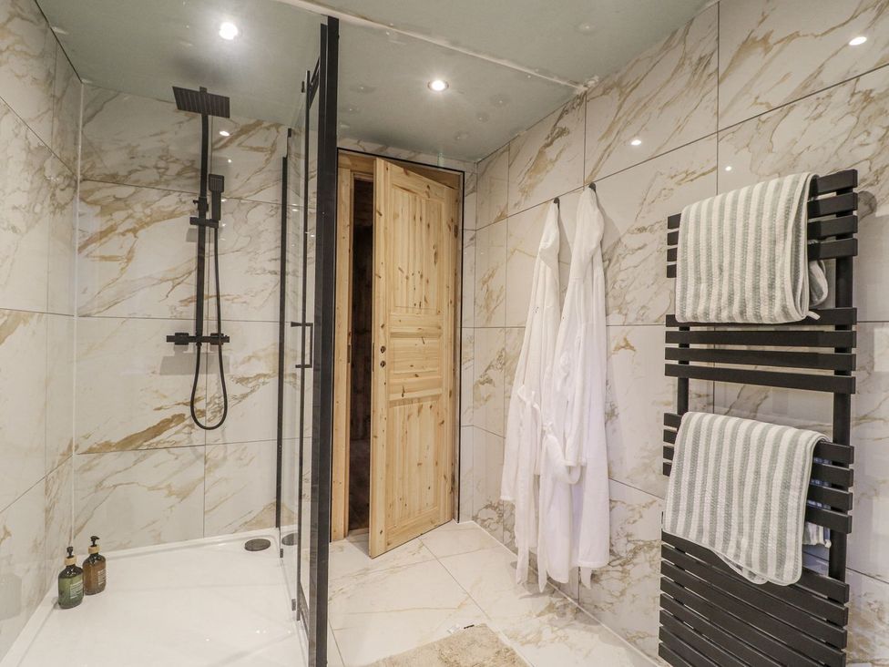 A bathroom with a shower and towel rack at Badger's Burrow in Edith Weston