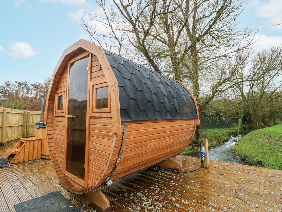 A wooden cabin located by a stream at Badger's Burrow in Edith Weston
