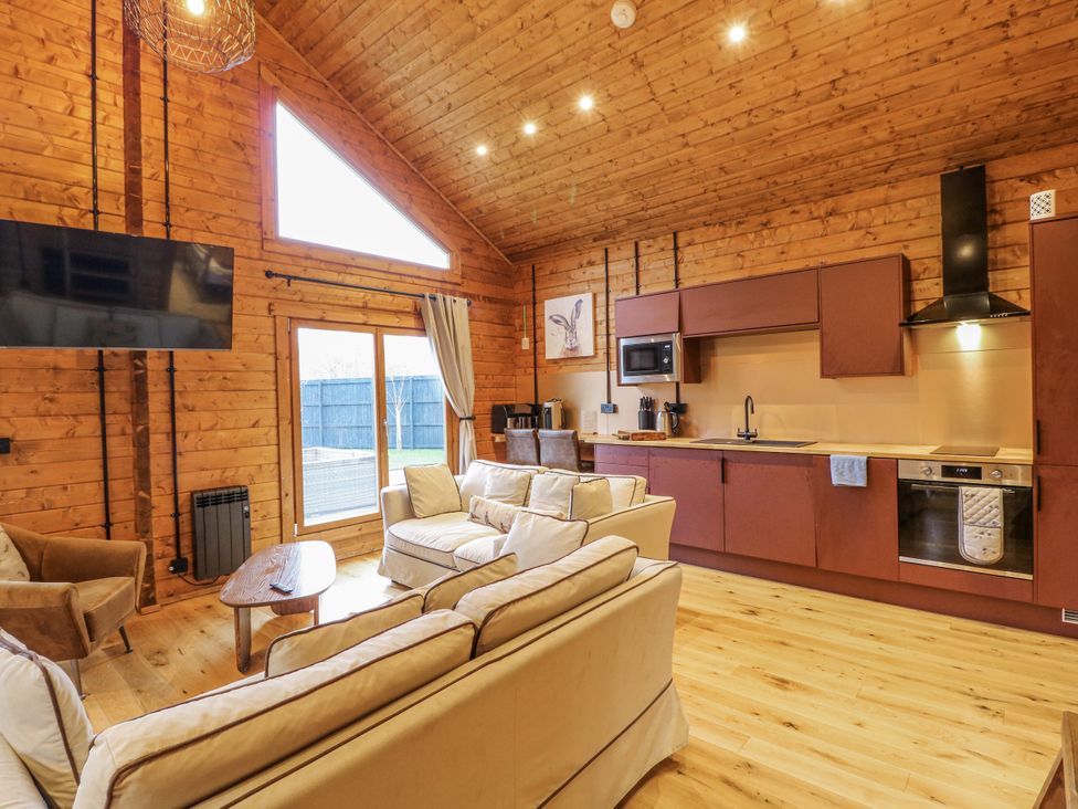 A living room with a sofa and kitchen area at Rabbit Hole near Stamford