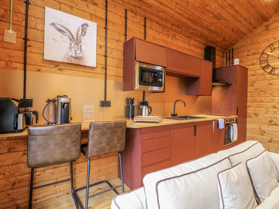 A kitchen with a sink and bar stools at Rabbit Hole near Stamford
