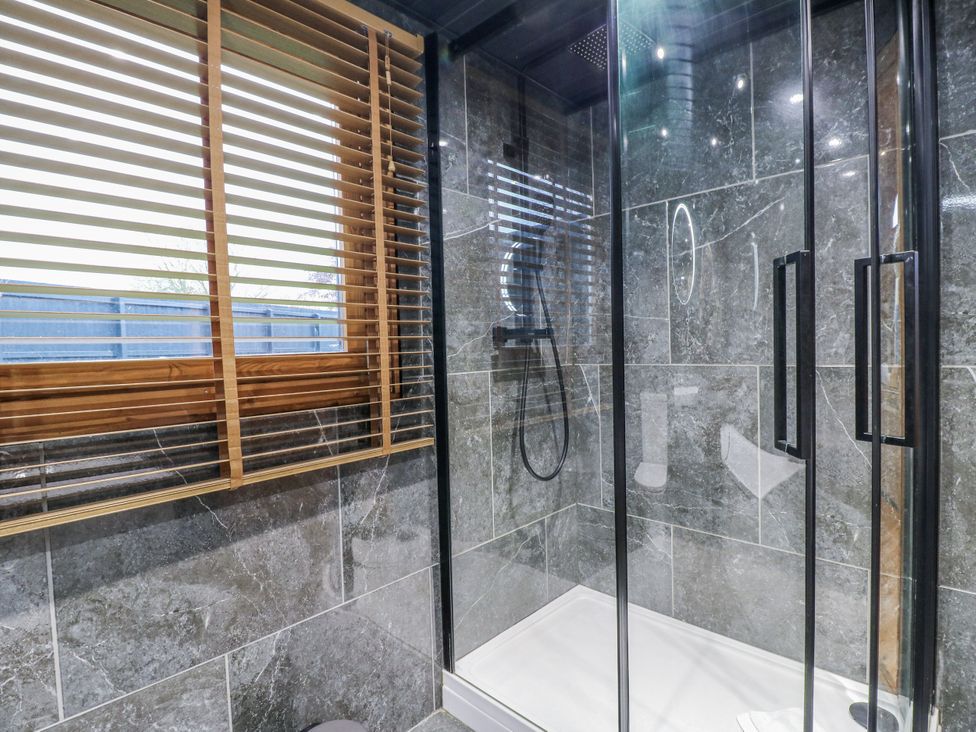 A bathroom with a shower and tiles at Rabbit Hole near Stamford