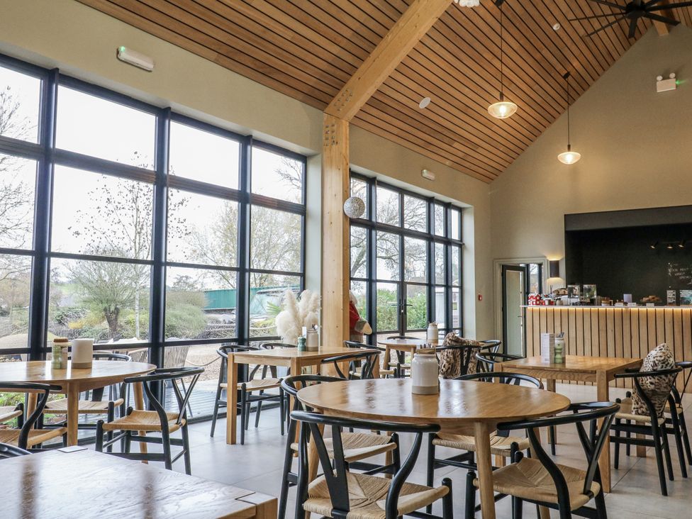 A café with wooden tables and chairs at Rabbit Hole near Stamford