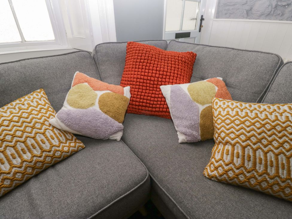 A sofa with patterned cushions at Unicorn Cottage