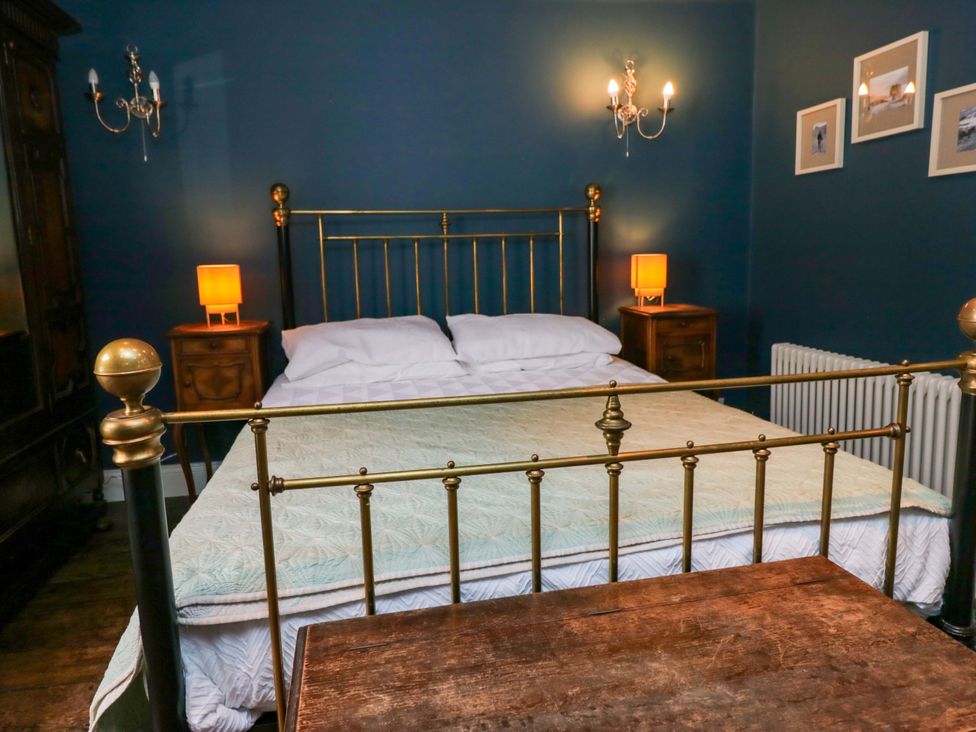 A bedroom with a bed and nightstands at Unicorn Cottage