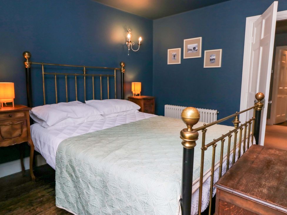 A bedroom with a bed and nightstands at Unicorn Cottage in 
