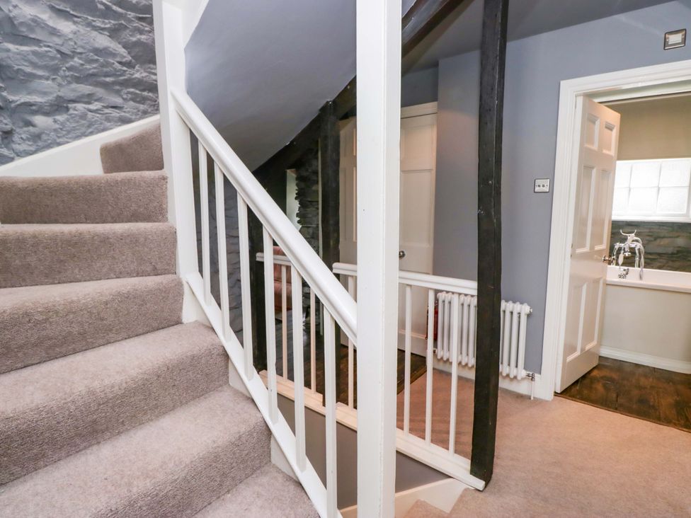 A hallway with stairs and a door at Unicorn Cottage