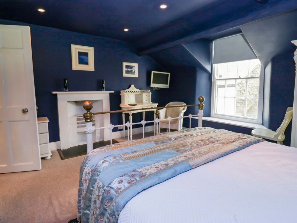 A bedroom with a bed and a desk at Unicorn Cottage in 
