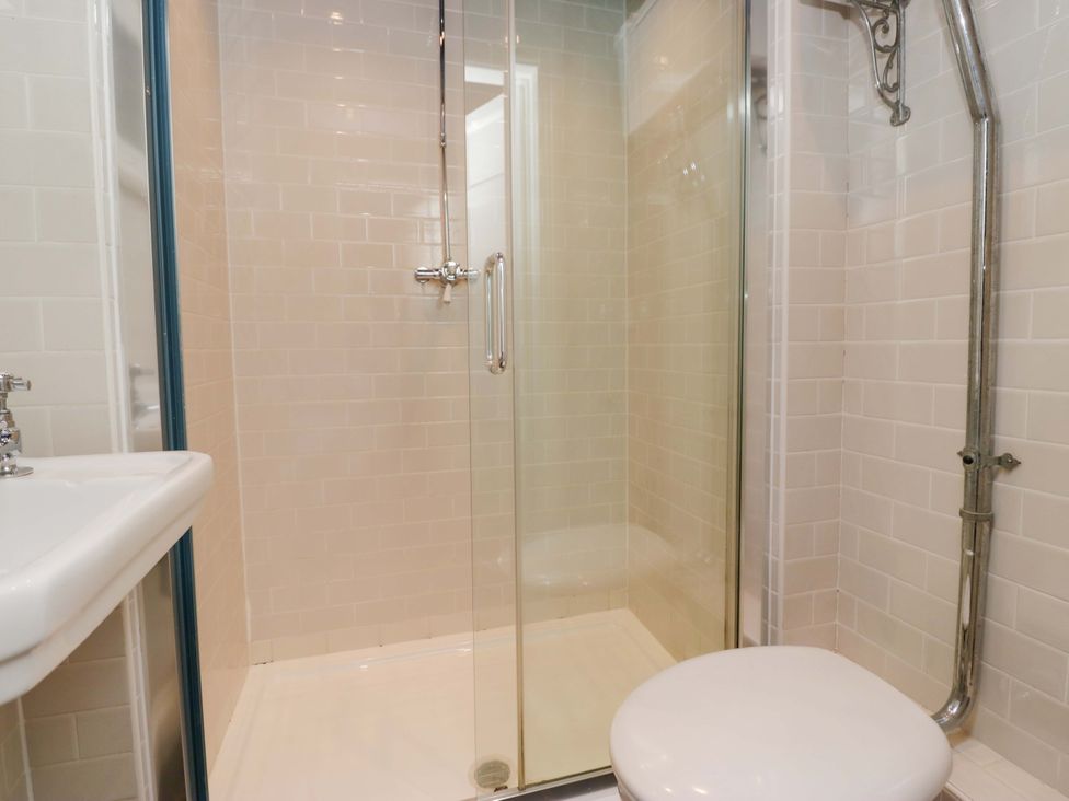 A bathroom with a shower, sink, and toilet at Unicorn Cottage in 