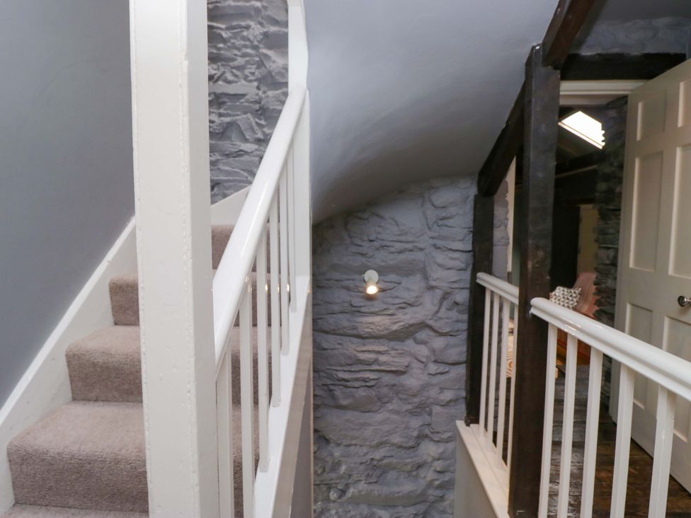 A staircase and railing in a hallway at Unicorn Cottage