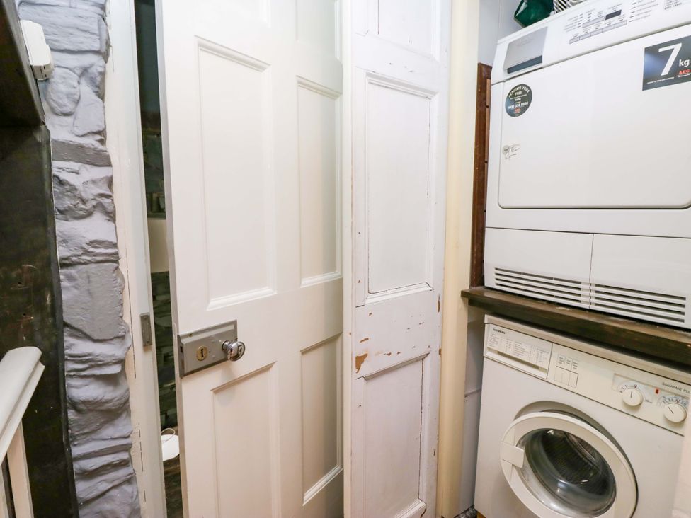 A laundry room with a washing machine and dryer at Unicorn Cottage