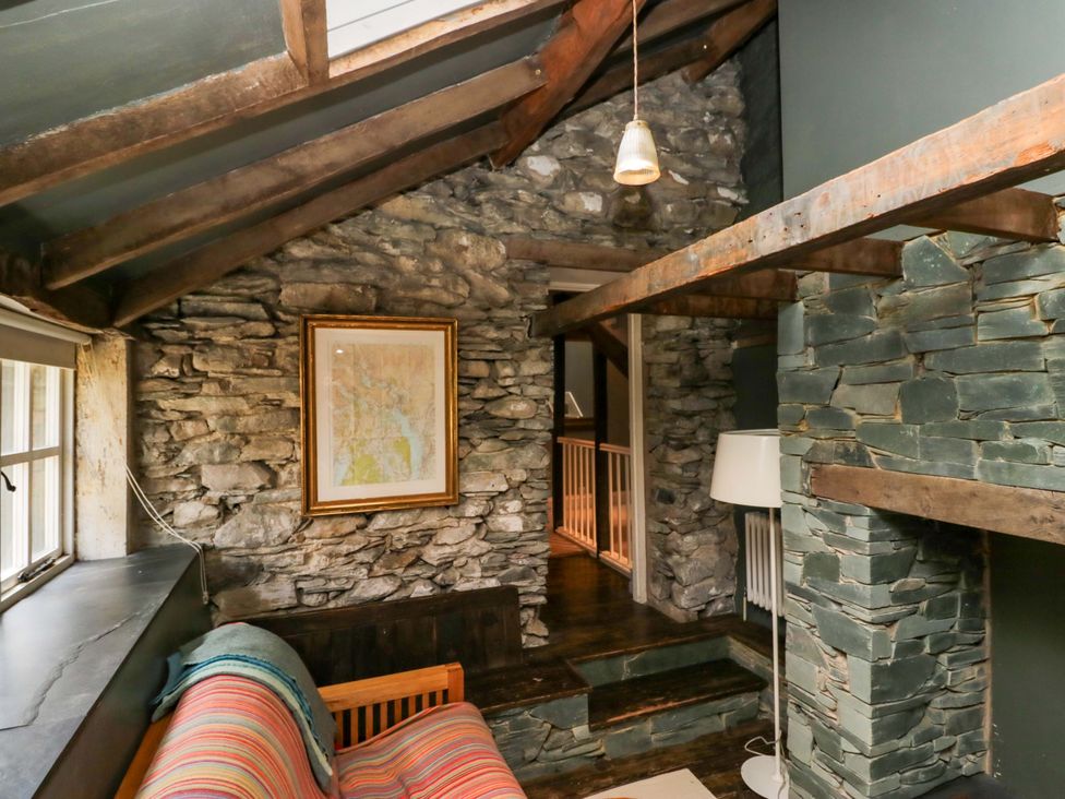 A living room with a sofa and a map on the wall at Unicorn Cottage
