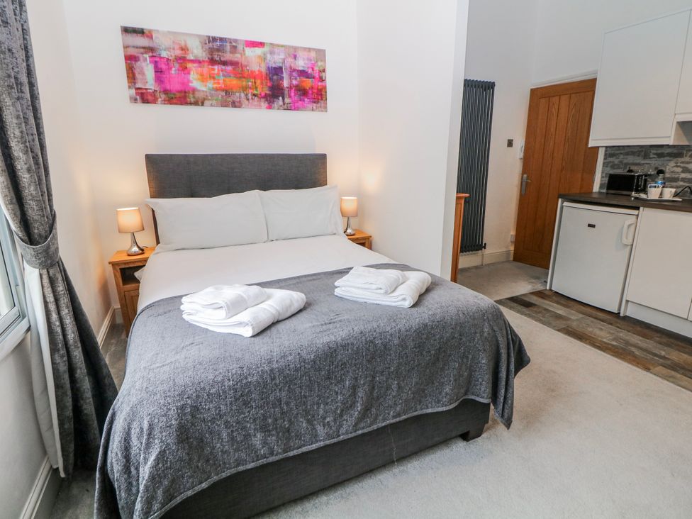 A bedroom with a bed and a mini fridge at Masson (78) in Matlock