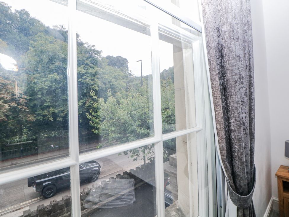 A view from a window with a curtain in a living room at Masson (78) Matlock