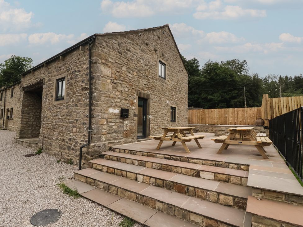 A stone house with steps and picnic tables at Virginia Cottage Skipton