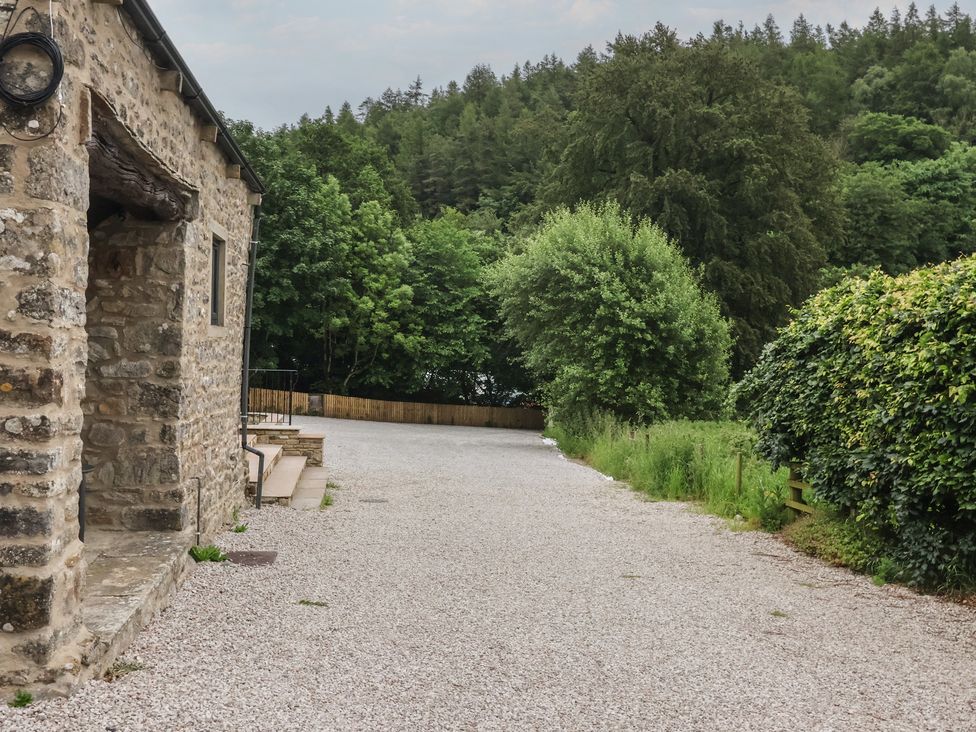 An outdoor area with a gravel path and stone wall at Virginia Cottage Skipton