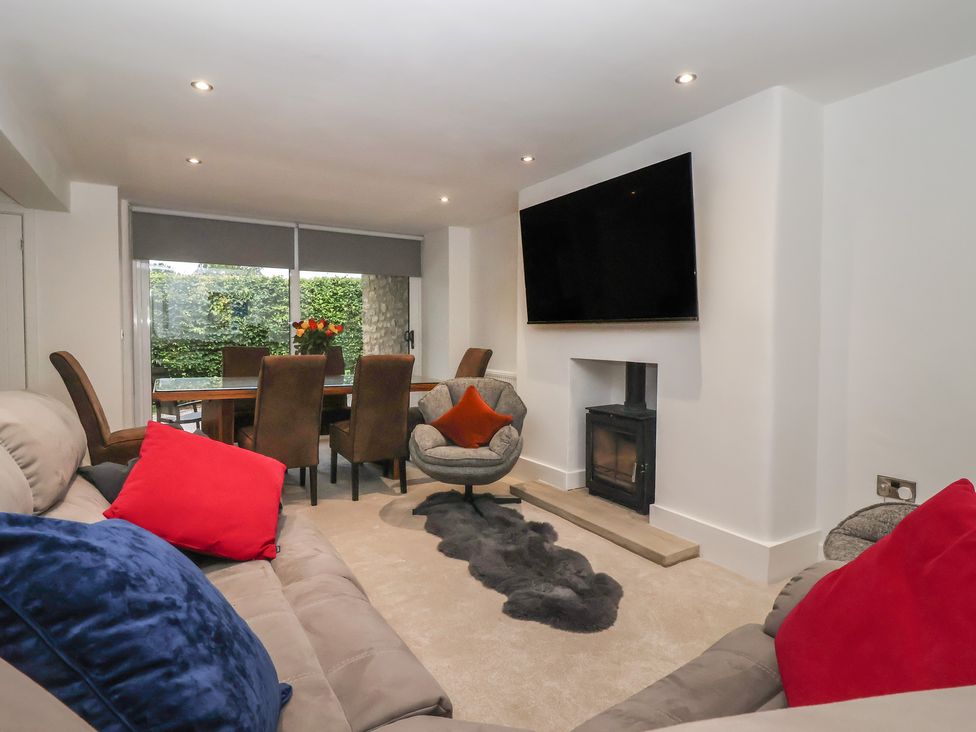 A living room with a sofa and television at Virginia Cottage in Skipton