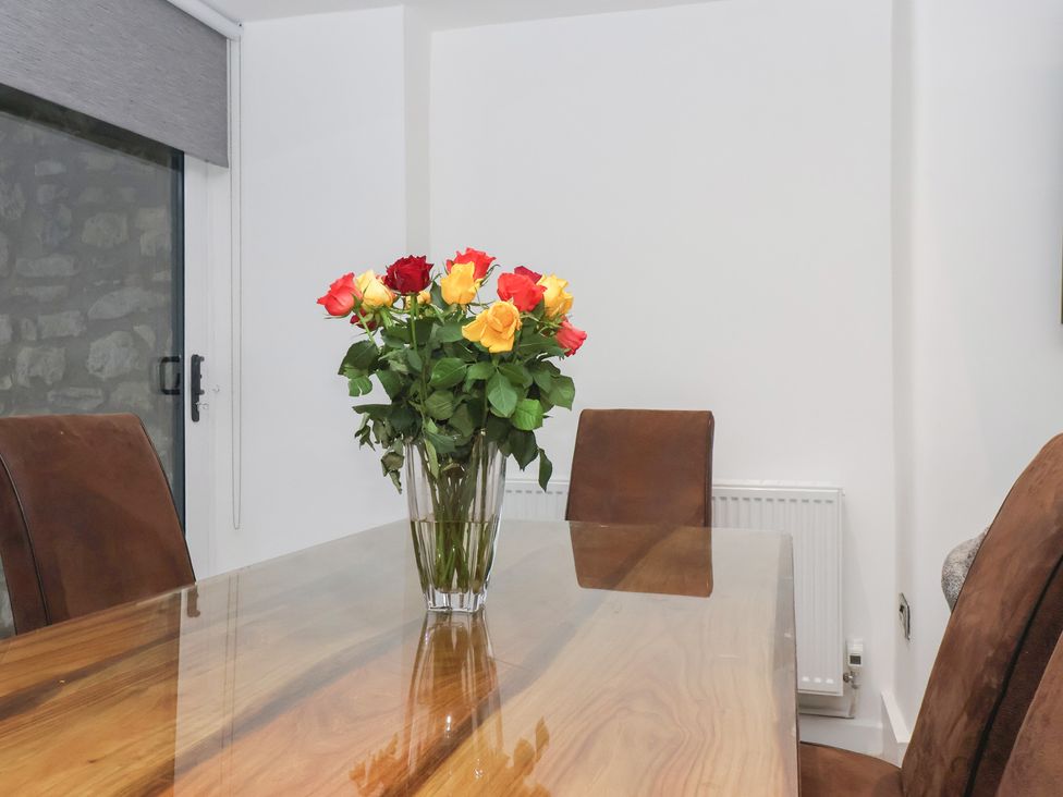 A dining room with a wooden table and chairs at Virginia Cottage in Skipton