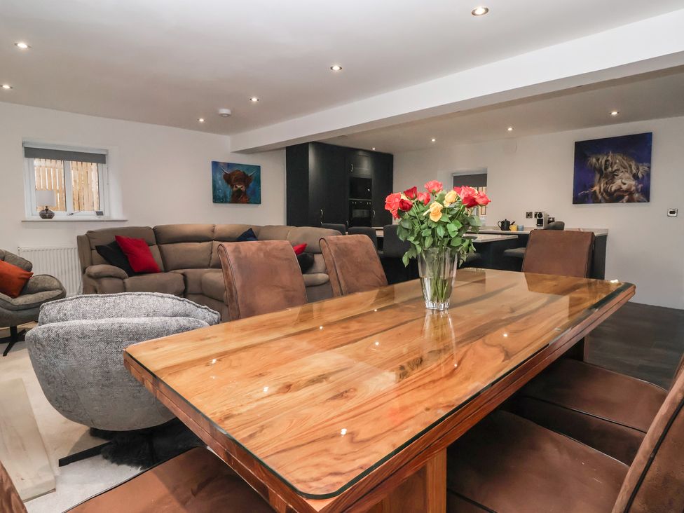 A dining room with a wooden table and chairs at Virginia Cottage in Skipton