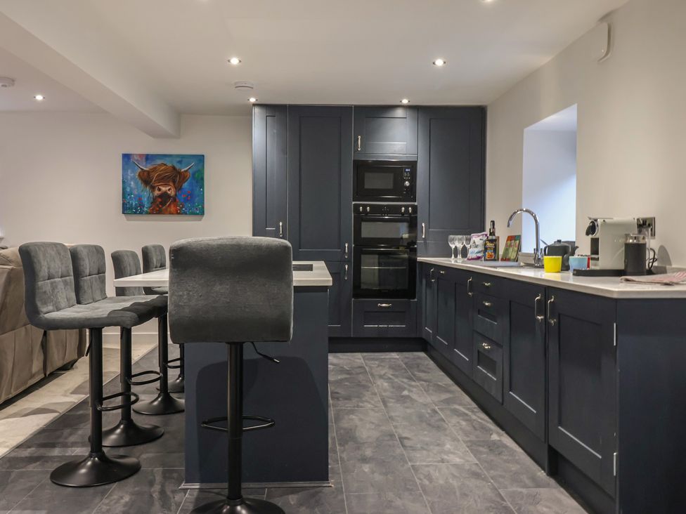 A kitchen with gray stools and appliances at Virginia Cottage in Skipton