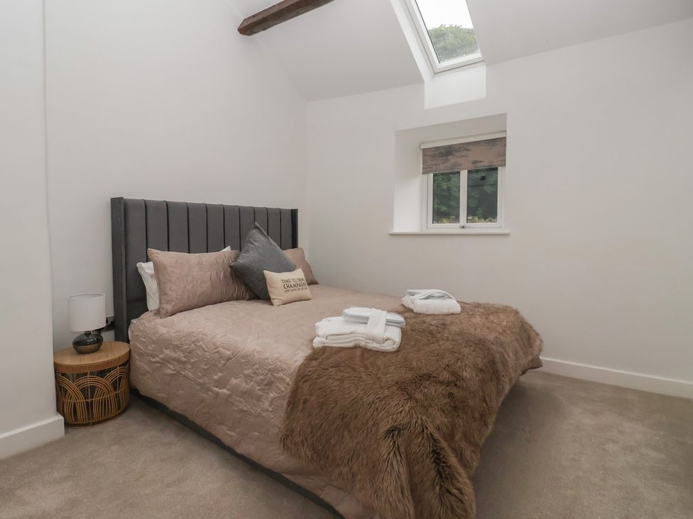 A bedroom with a bed and a bedside table at Virginia Cottage in Skipton