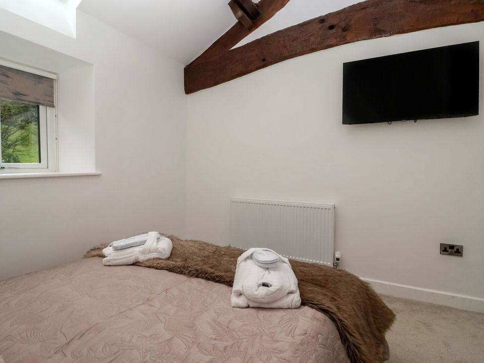 A bedroom with a bed and towel at Virginia Cottage in Skipton