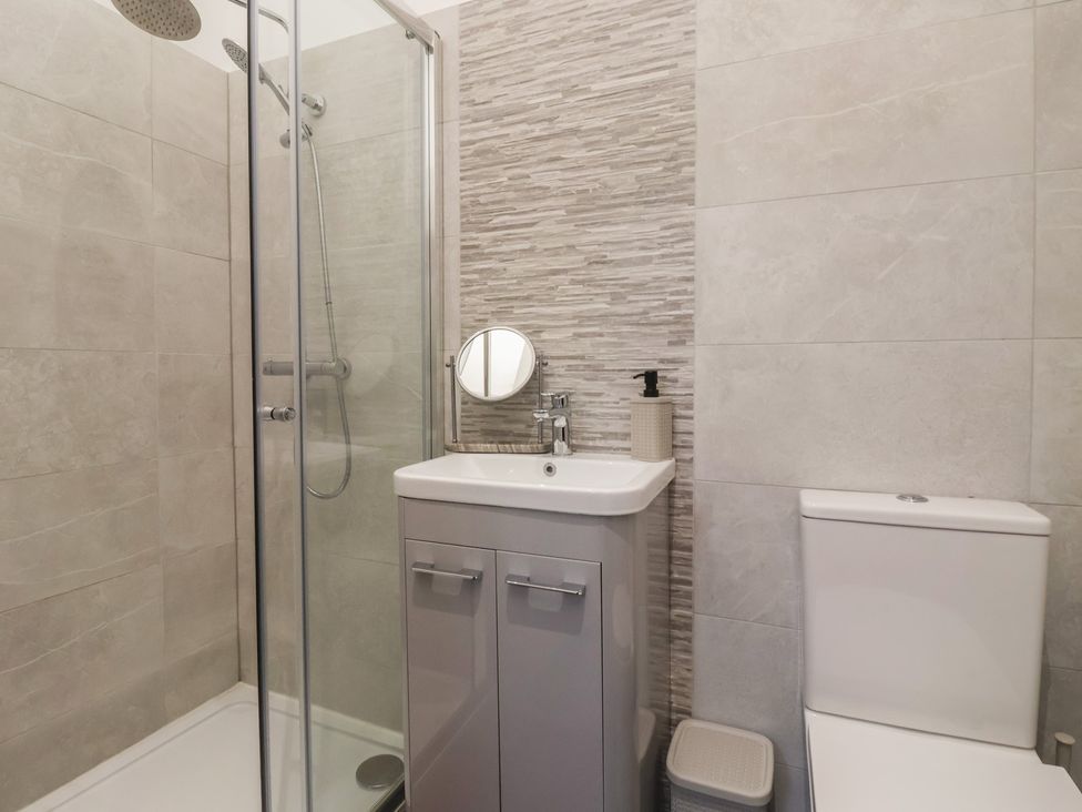 A bathroom with a shower, sink, and toilet at Virginia Cottage in Skipton
